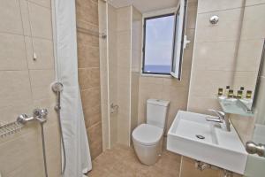 a bathroom with a toilet and a sink and a shower at Nafsika Hotel in Rhodes Town