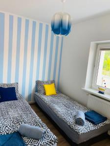 a room with two beds and a window at Apartament Morski in Jarosławiec