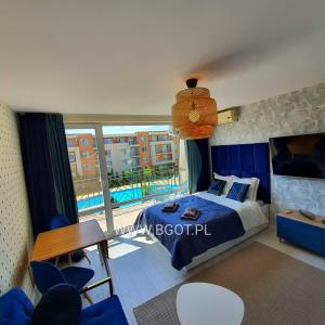 a bedroom with a bed and a balcony with a pool at Holiday Fort Golf Club - Premium Apartments in Sunny Beach