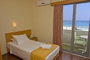 a bedroom with a bed and a view of the ocean at Nafsika Hotel in Rhodes Town