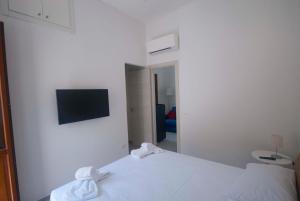 a bedroom with a white bed and a mirror at GIADA in Castellammare del Golfo