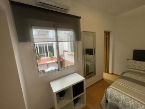 mała sypialnia z łóżkiem i oknem w obiekcie CASITA ANDALUZA CENTRO con PARKING sujeto a disponibilidad w Maladze