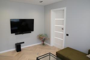 a living room with a flat screen tv on a wall at Birutės parko apartamentai in Palanga