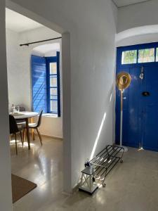 een kamer met een blauwe deur en een tafel en stoelen bij Veneto's Garden in Kardhamili