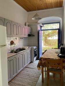 a kitchen with white cabinets and a table and a window at Veneto's Garden in Kardamyli +10 photos