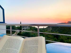 an open book sitting on a table with a sunset at Itaka Hotel Lukova in Lukovë +89 photos
