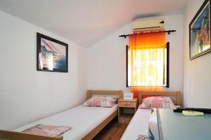 a room with two beds and a window at Sofia Rooms in Tivat +1 photo