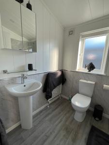 a bathroom with a sink and a toilet and a mirror at Beach Base Lodge, Padstow Cornwall in Padstow