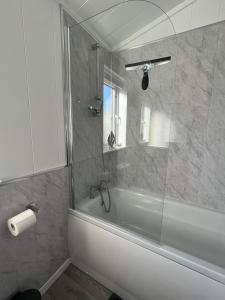 a bathroom with a tub and a glass shower at Beach Base Lodge, Padstow Cornwall in Padstow