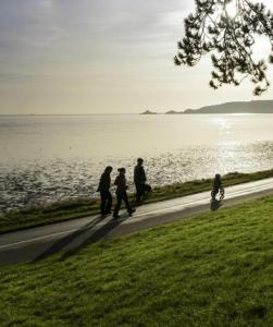 a group of people walking down a path next to the water at 40 Carlton Tce F1 in Swansea