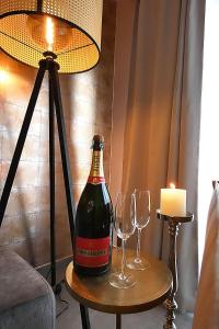 eine Flasche Wein auf dem Tisch mit zwei Gläsern in der Unterkunft SuiteDreams - Relax Suite Liège in Lüttich