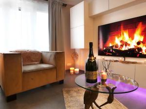 soggiorno con una bottiglia di vino e un camino di SuiteDreams - Relax Suite Liège a Liegi