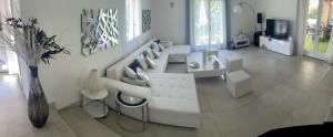 Sala de estar blanca con sofá blanco y mesa en VILLA LES YUCCAS - Pool - Sea view, en Cagnes-sur-Mer