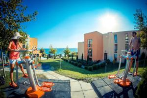 un homme et une femme jouant sur une aire de jeux dans l'établissement Grand Resort - Sea Viev and Premium Apartments, à Sveti Vlas
