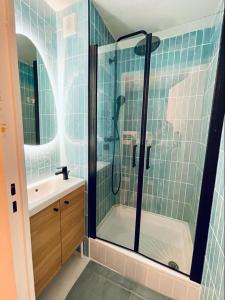 uma casa de banho com um chuveiro e um lavatório. em Flore em Le Grau-du-Roi