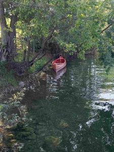 een rode boot in het midden van een rivier bij Kuca za odmor Braco in Donji Zvečaj
