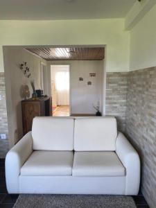 een witte bank in een woonkamer met een bakstenen muur bij Casa dos Avós in Póvoa de Lanhoso