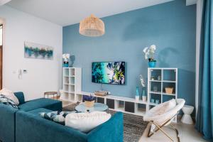 ein Wohnzimmer mit blauen Wänden und einem blauen Sofa in der Unterkunft Family vacation villa with private pool and access to beach in Ras al Khaimah