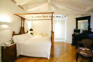 a bedroom with a bed and a desk and a television at Tartheshotel in Guspini