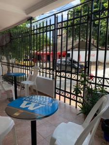 een patio met een tafel en stoelen en uitzicht op een straat bij Hostal Casa W in Cartagena