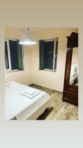 a bedroom with a bed with a mirror and a lamp at KRATHIS APARTMENTS ΜΕΓΑΛΟ in Paralía Platánou