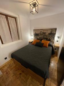 een slaapkamer met een groot bed met oranje kussens bij Apartamento Grace in Sintra