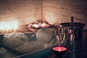 a bath tub with candles and a bowl of food at Tartheshotel in Guspini