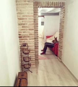 una donna seduta su un divano rosso in un soggiorno di El Nido: Una casita de ensueño a Deltebre