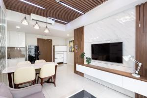 cocina y sala de estar con mesa de comedor y TV. en Blue Fingers Masteri An Phu, en Ho Chi Minh