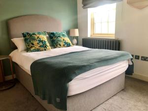 una camera da letto con un grande letto con una coperta verde di Quarry House a Stamford