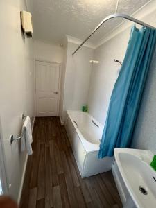 a bathroom with a bath tub and a sink at Spacious Entire Flat, 1 in Great Yarmouth