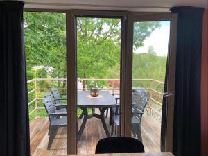 a table and chairs on a deck with sliding glass doors at Enjoy Durbuy 5 in Durbuy