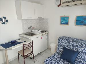 a kitchen with a table and a chair and a sink at Apartmani More in Petrovac na Moru