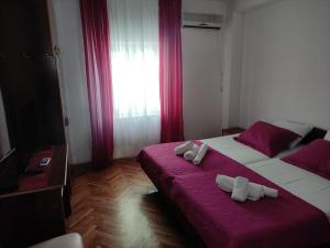 Habitación de hotel con 2 camas y toallas. en Apartmani More, en Petrovac na Moru