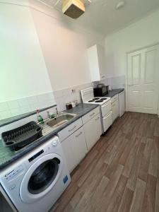 a kitchen with a washing machine and a sink at Spacious Entire Flat, 1 in Great Yarmouth