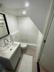 een witte badkamer met een wastafel en een toilet bij DOWN UNDER in Veere in Veere