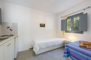 a small bedroom with a bed and a window at Anna Studios Paros in Naousa