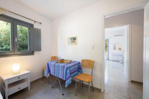 a dining room with a table and chairs and a room at Anna Studios Paros in Naousa
