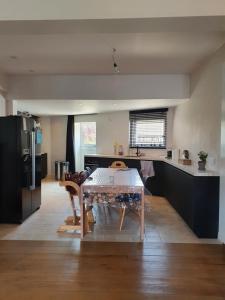 a kitchen with a table and a kitchen with black cabinets at Stijlvolle vakantiewoning Den Baigneur aan zee in Knokke-Heist