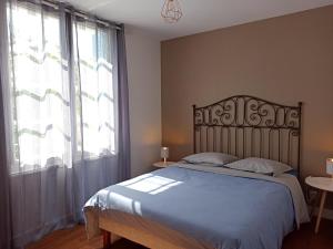 a bedroom with a bed and a large window at Maison 6 personnes - grand jardin arboré in Noyers-sur-Cher