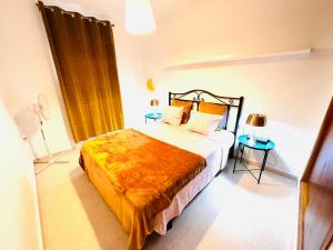 a bedroom with a bed with an orange blanket on it at Apartamento Rincón, Ideal para familias in Cala del Moral +26 photos