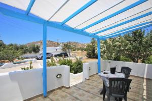 a pergola with a table and chairs on a patio at Alice Maisonette & Studios in Adamantas