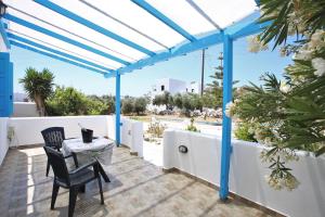 a pergola with a table and chairs on a patio at Alice Maisonette & Studios in Adamantas