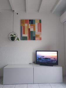 un televisor sentado sobre una mesa blanca en Studio tout confort centre ville - Balcon, Clim, TV, Wifi, en Mazan
