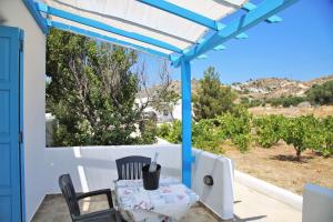 a table and chairs on the porch of a house at Alice Maisonette & Studios in Adamantas