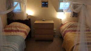 een slaapkamer met 2 bedden, een dressoir en 2 lampen bij B&B Verwoldsehof 'Op de deel' in Laren