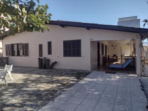 Casa no centro em Garopaba في غاروبابا: منزل أبيض مع شرفة وفناء +11 صورة