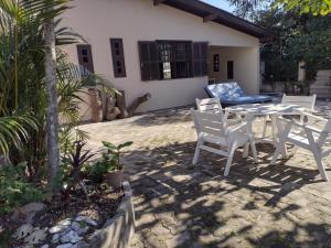 Casa no centro em Garopaba في غاروبابا: فناء مع طاولة وكراسي أمام المنزل