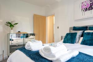 a bedroom with two beds with towels on them at Butterfly House - Luxury 2 Bedroom Property in Kettering