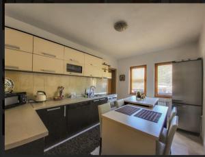 a kitchen with a stainless steel refrigerator and a table at Nera-etwa Konjic 1 apartment in Konjic